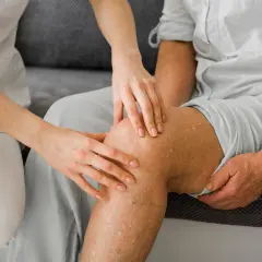 Ärztin untersucht Knie, um runners knee symptome zu identifizieren.