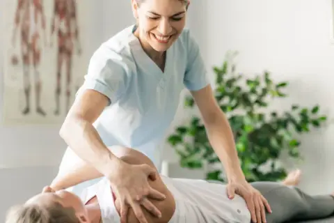 Therapeutin bei Physiotherapie und Osteopathie behandelt Patientin am Rücken.