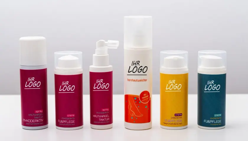 Sechs verschiedene Flaschen mit **Fußpflege**-Produkten, darunter Sprays und Cremes, stehen nebeneinander.