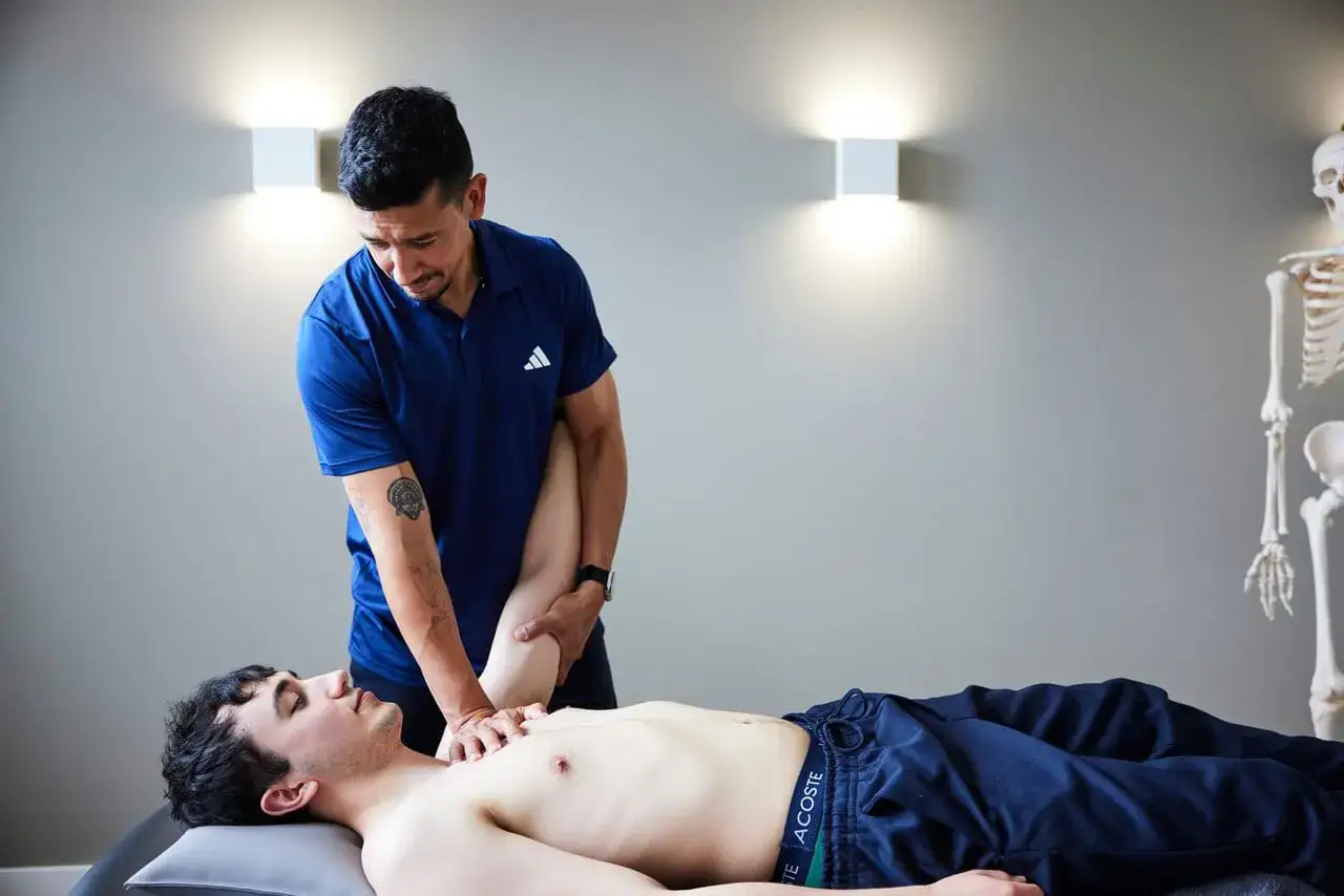Osteopath behandelt einen Patienten mit Frozen Shoulder. Sanfte H&auml;nde mobilisieren den Arm f&uuml;r mehr Beweglichkeit.